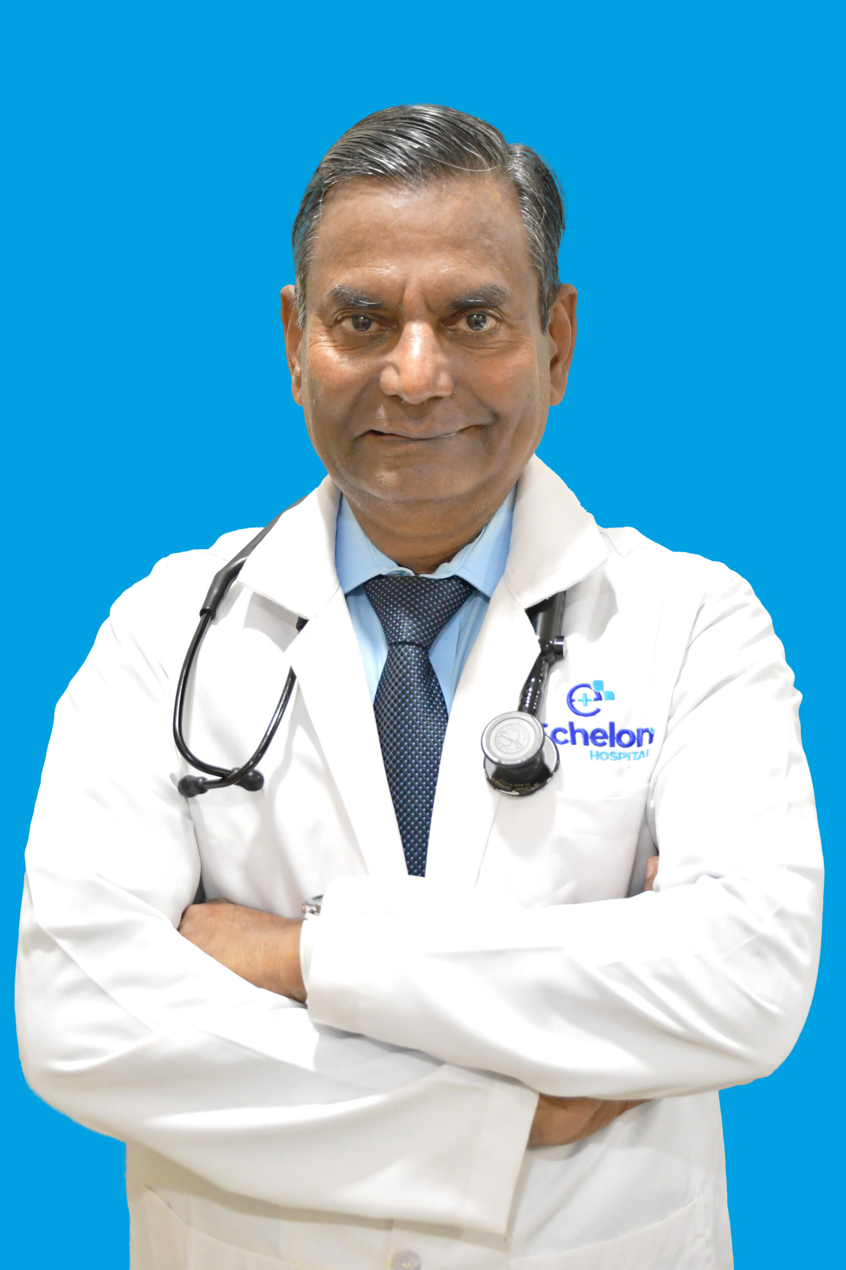 Male doctor in a white coat with a stethoscope, arms crossed, against a bright blue background.