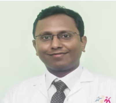 Portrait of a male doctor in a white coat and tie, smiling at the camera.