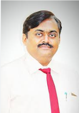 Portrait of a man with a mustache wearing a white shirt and red tie against a light background, looking at the camera.
