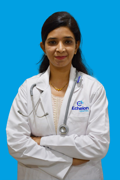 Female doctor in white coat with stethoscope, arms crossed, standing against a blue background.