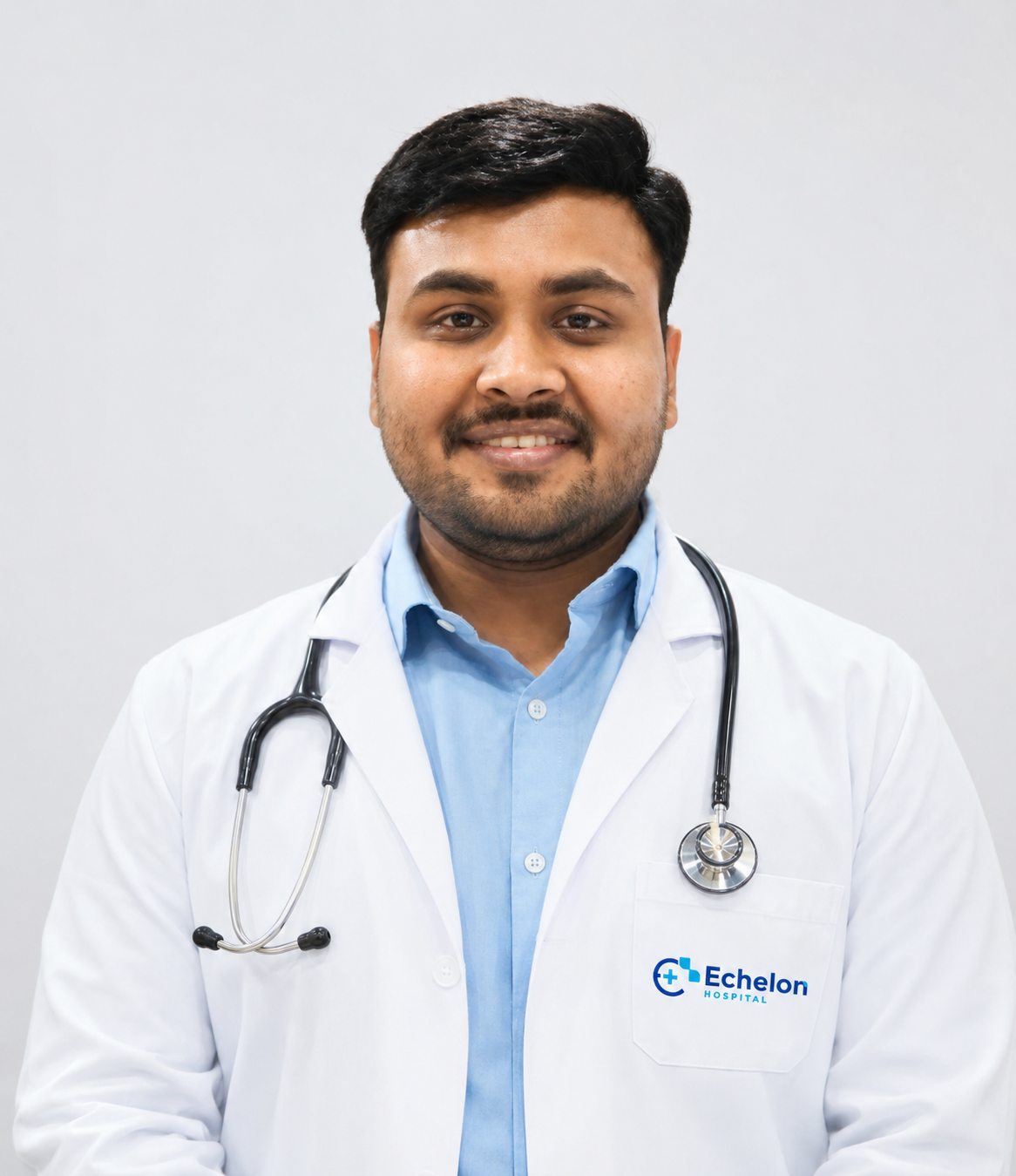 Male doctor in a white coat with a stethoscope, smiling at the camera, Echelon Hospital logo on the coat pocket.