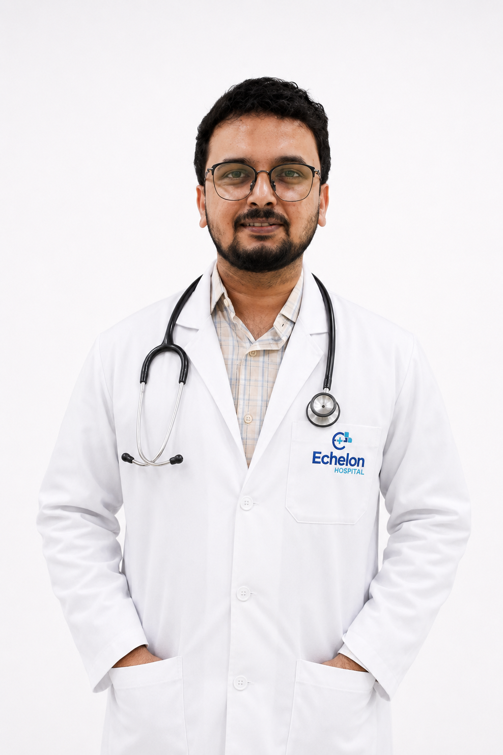 Male doctor with glasses in a white lab coat, stethoscope around the neck, hands in pockets, Echelon Hospital logo on the pocket patch.