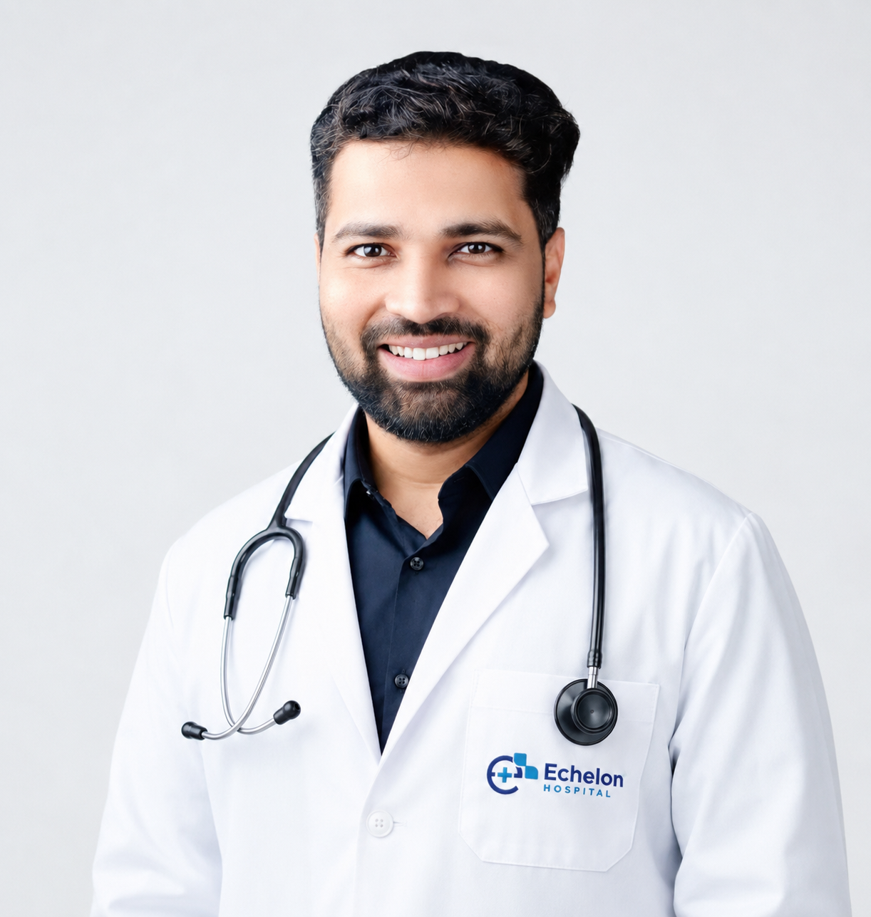 Male doctor in a white coat with a stethoscope, smiling, Echelon Hospital logo on the pocket.