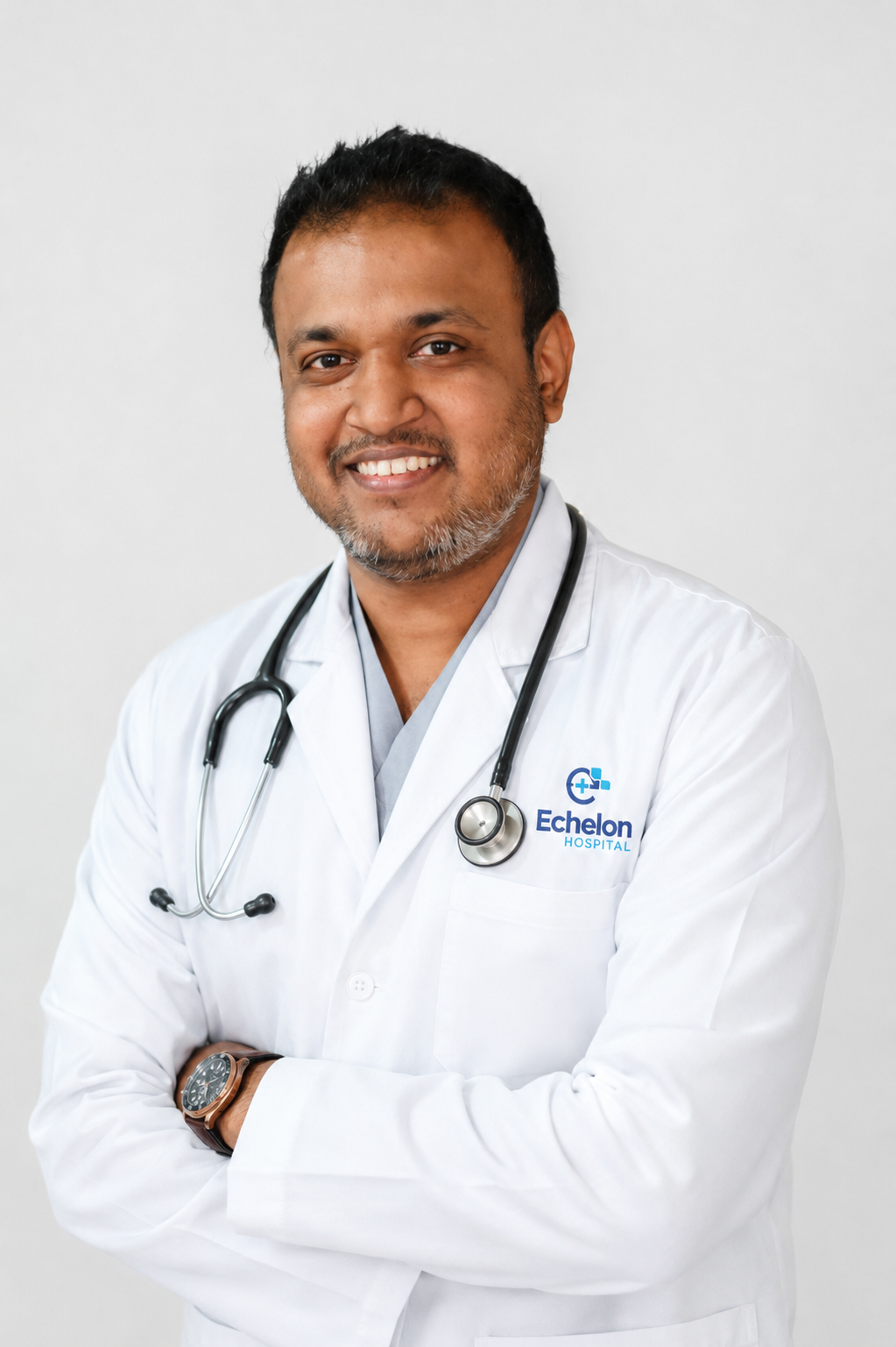 Smiling male doctor in a white coat with a stethoscope, arms crossed, Echelon Hospital logo on his chest.