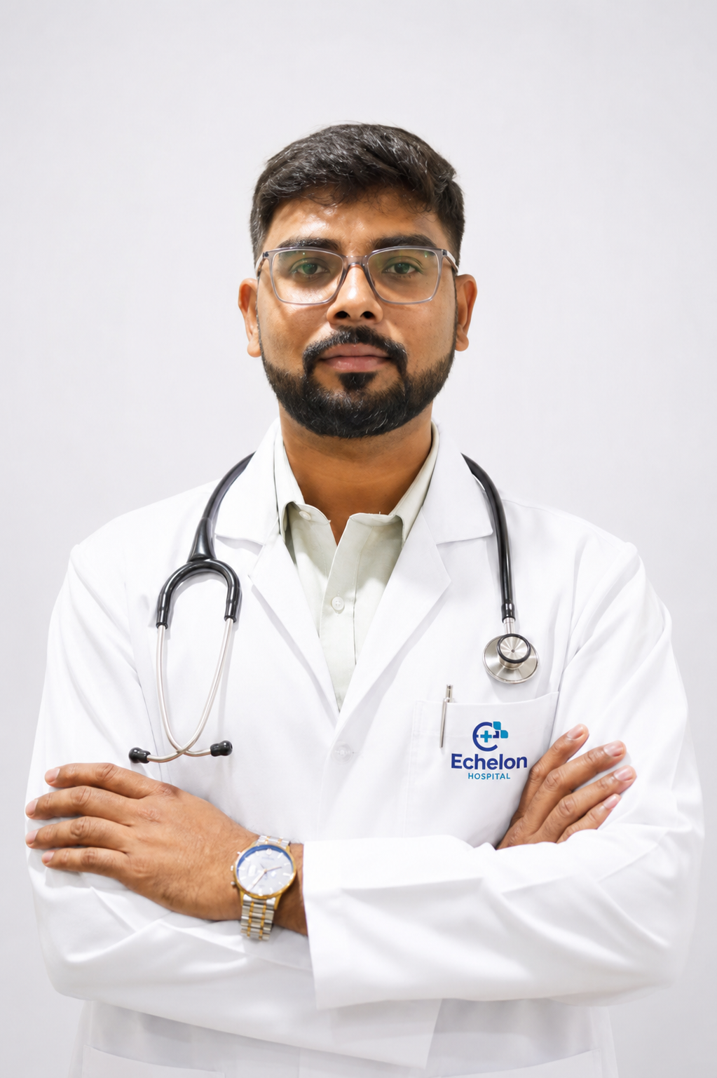Male doctor in a white coat with a stethoscope around his neck, arms crossed, Echelon Hospital logo on pocket