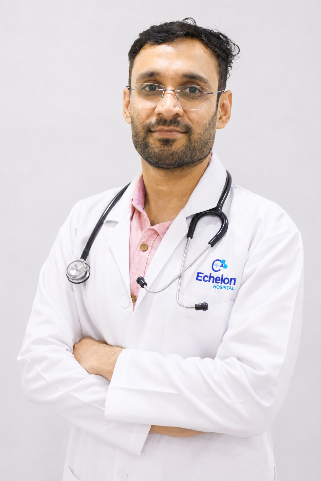 Male doctor in a white coat with a stethoscope, arms crossed, Echelon Hospital logo visible on the coat.