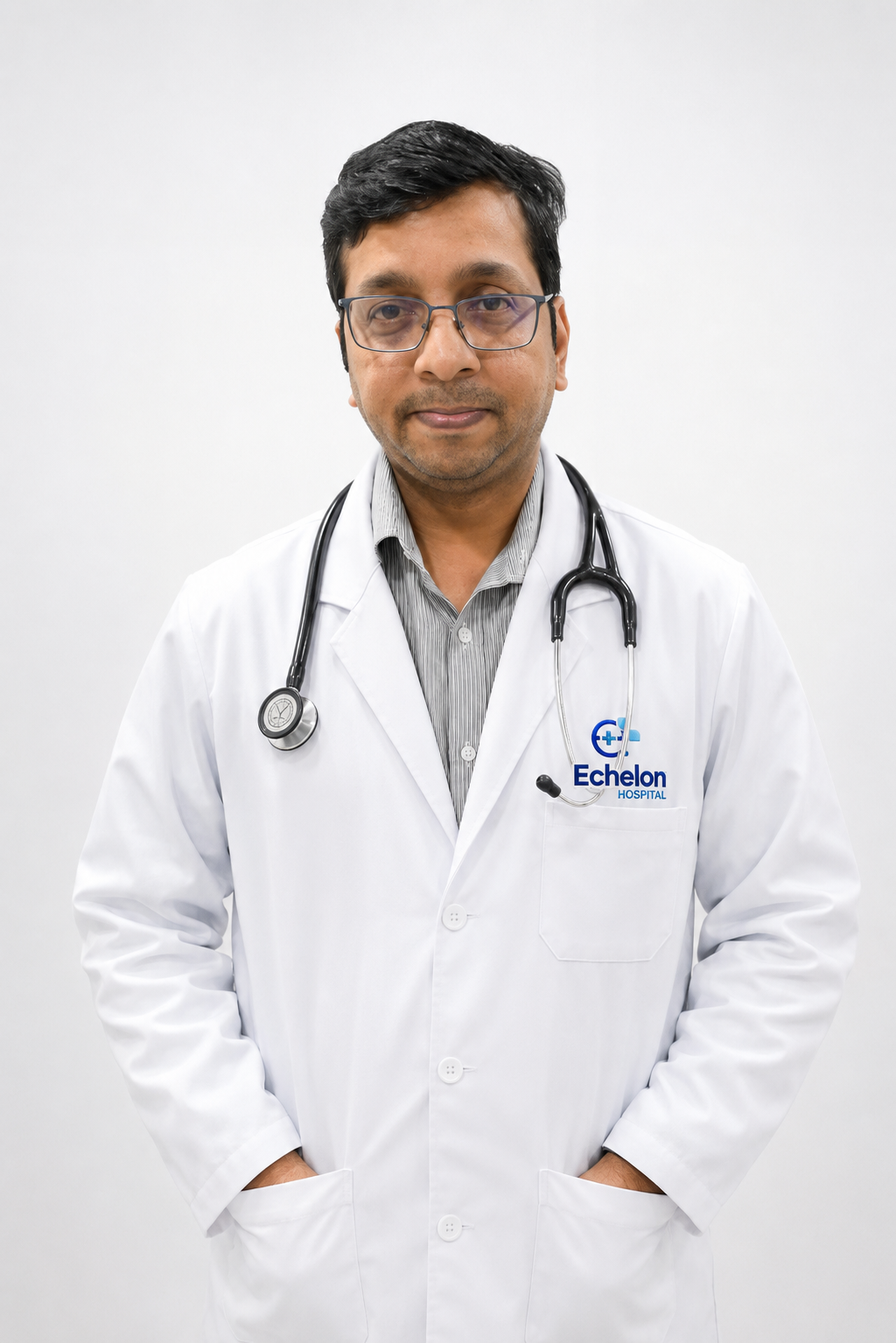 Male doctor in a white coat with a stethoscope around his neck, standing with hands in pockets against a white background.