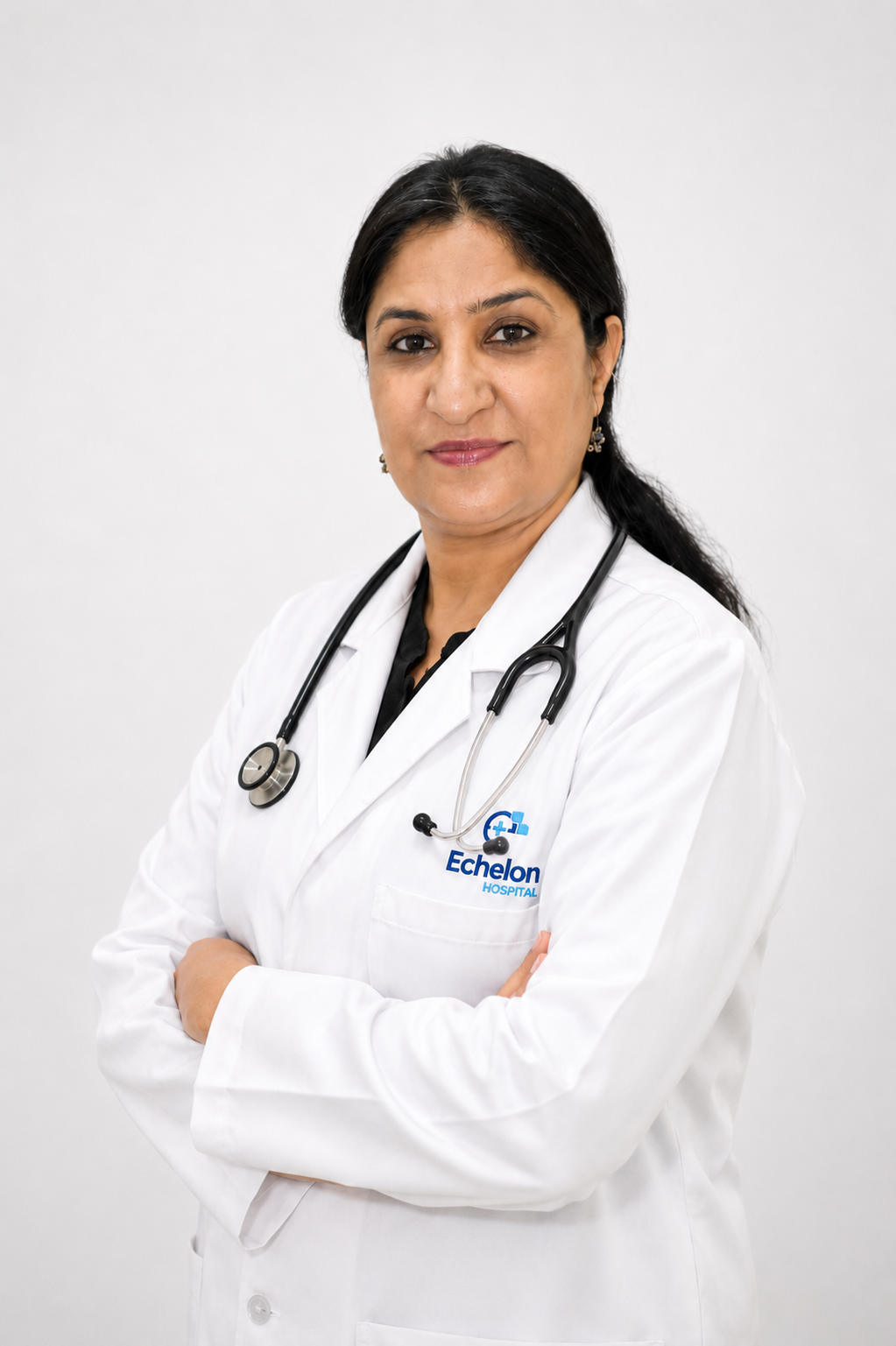 Portrait of a female doctor in a white coat with arms crossed against a blue background, Echelon Hospital logo on the coat.