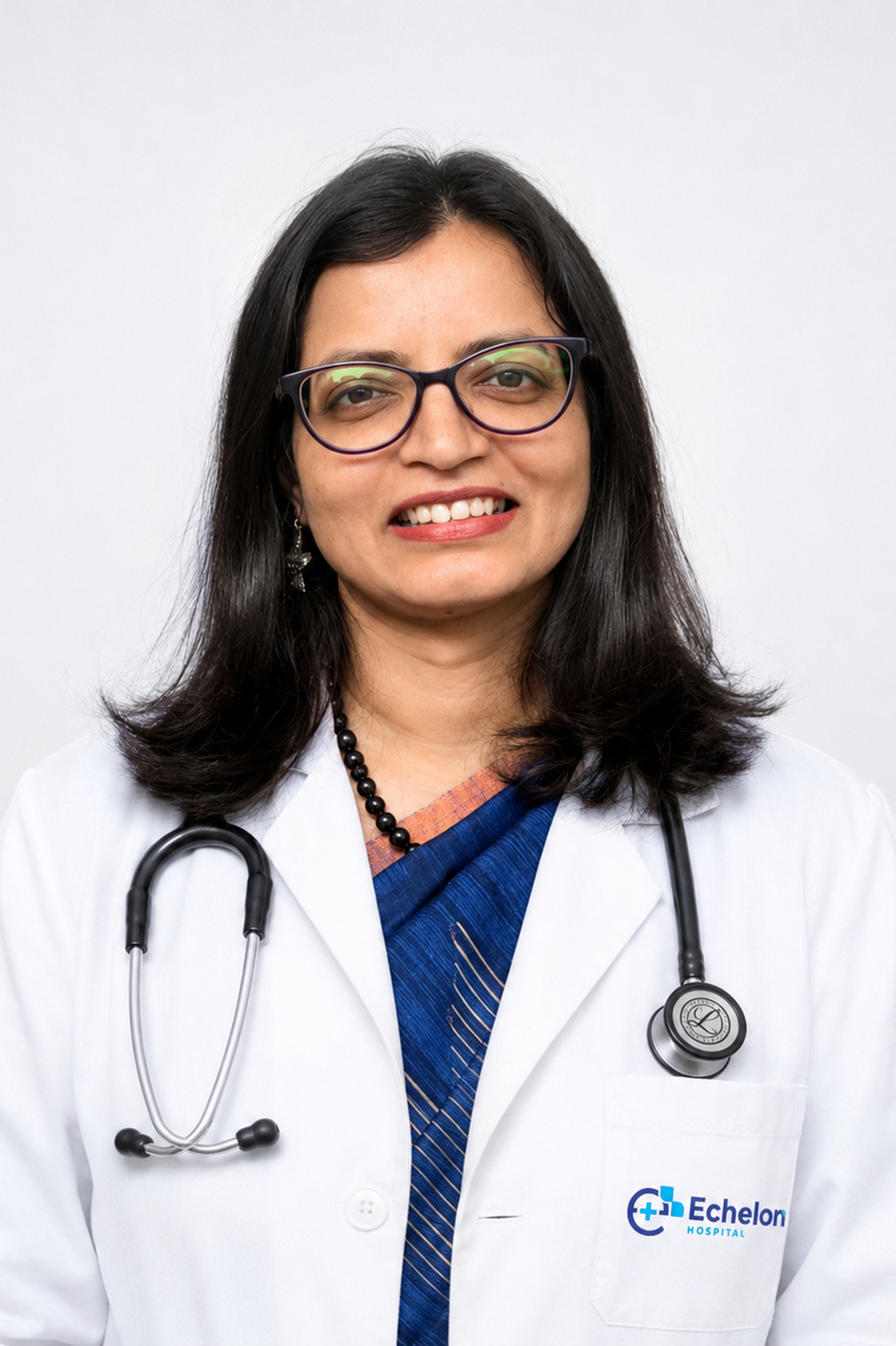 Smiling female doctor with glasses in a white coat, stethoscope around her neck, Echelon Hospital logo on pocket.